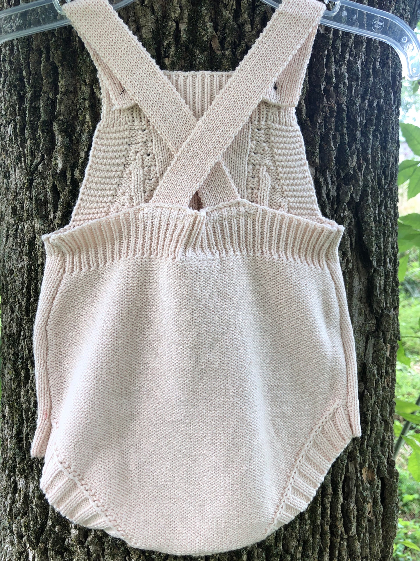 back of knit cotton romper for baby in cream outdoor photos of baby clothing